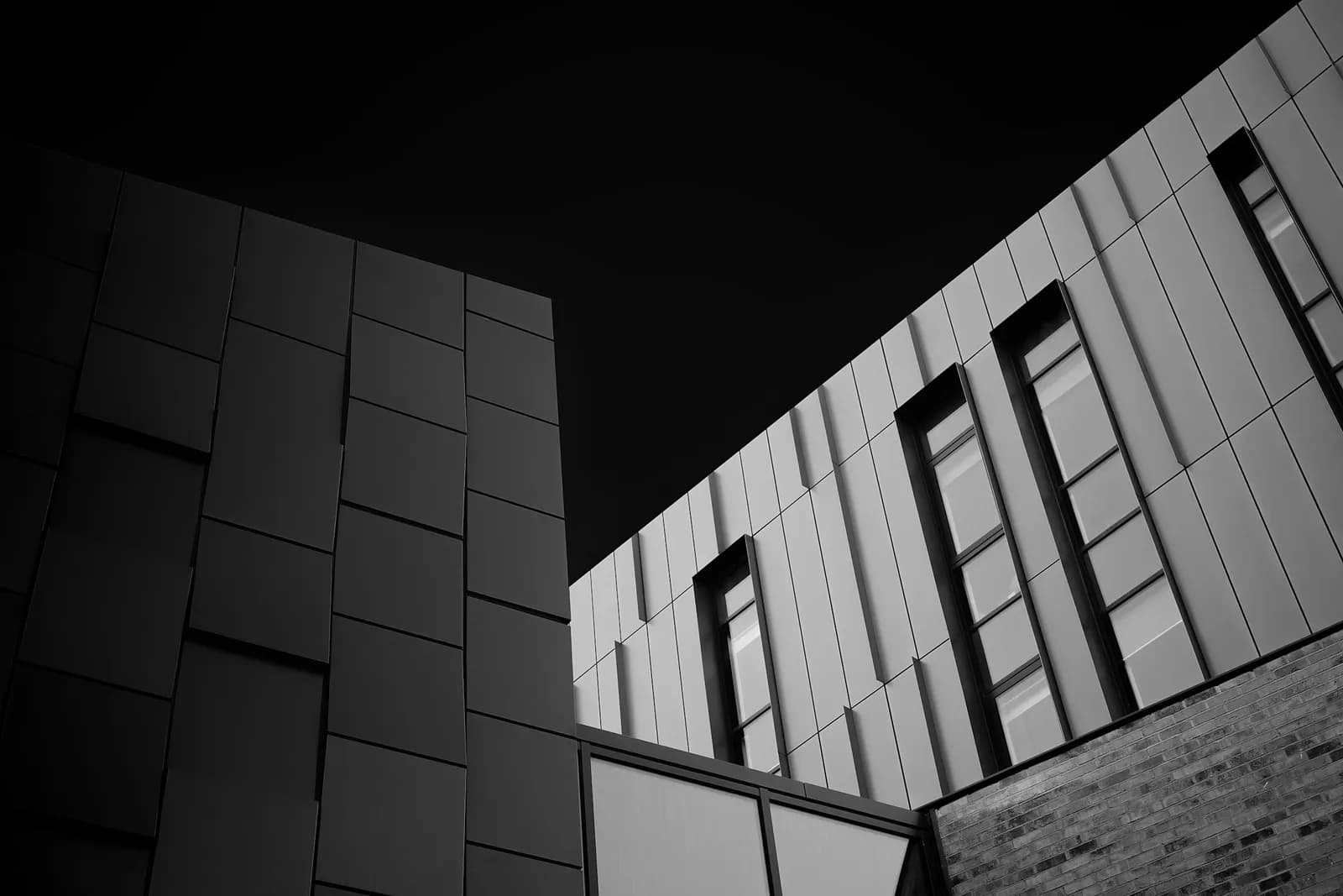 Angular building facade abstraction with dark panels and strong lines