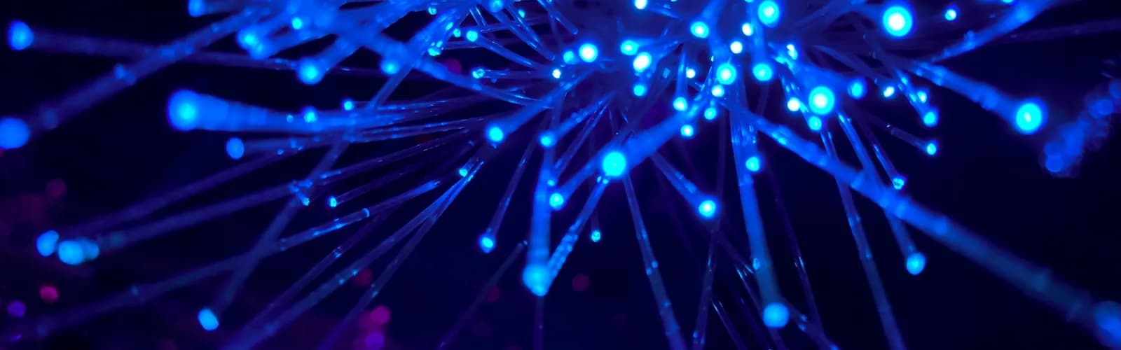 Blue fiber optic strands glowing against a dark background